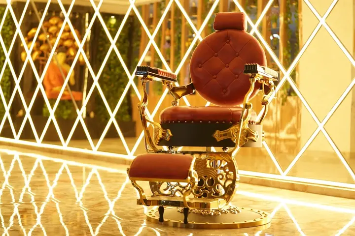 A gold and leather barber chair at the Hiwaga Gachibowli salon