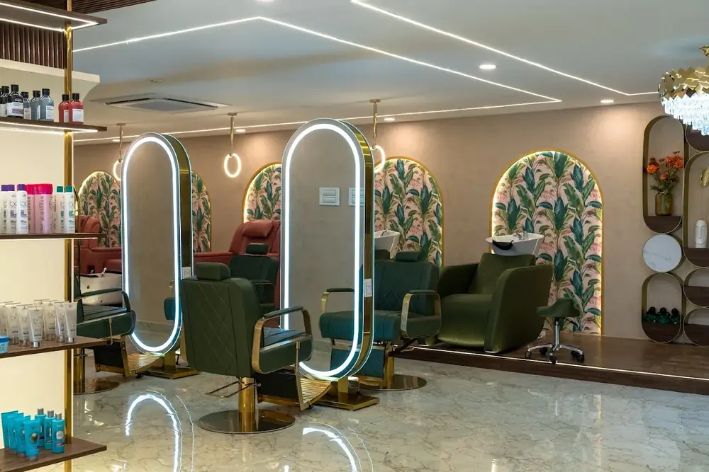 Lit oval mirrors and styling chairs at the Hiwaga Rajahmundry salon